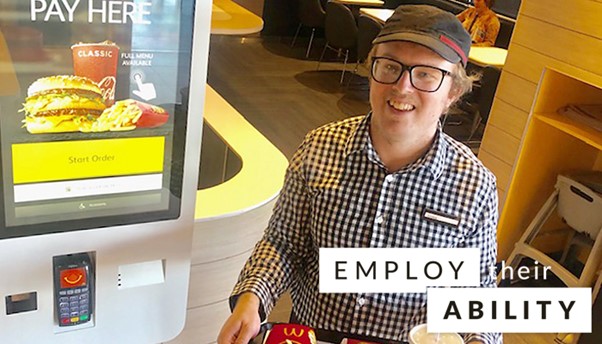 MacDonald's employee standing with a food try. Words "employ their ability" stamped on. 