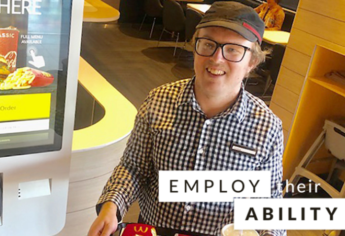 Christopher Croker, Employee at McDonald’s standing at work with a food tray with the words "employe their ability" stamped on the image. 